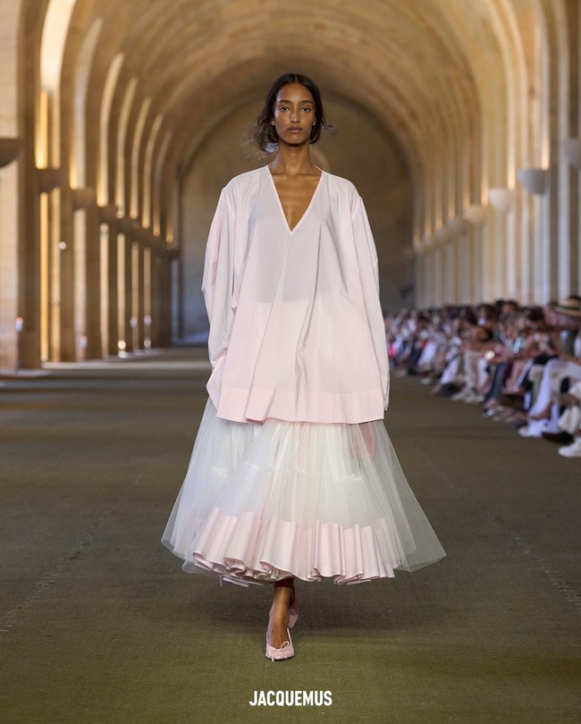 Garis busana tetap menawarkan sensualitas musim panas yang khas Jacquemus: gaun chiffon lengan kelelawar, tulle bordir bergaya halter yang melayang lembut di tubuh. Beberapa desain lain tampil minimalis namun memikat, seperti tank dress krim dan hitam dengan aksen apron yang lebih ramping. (Foto: Dok. Jacquemus)