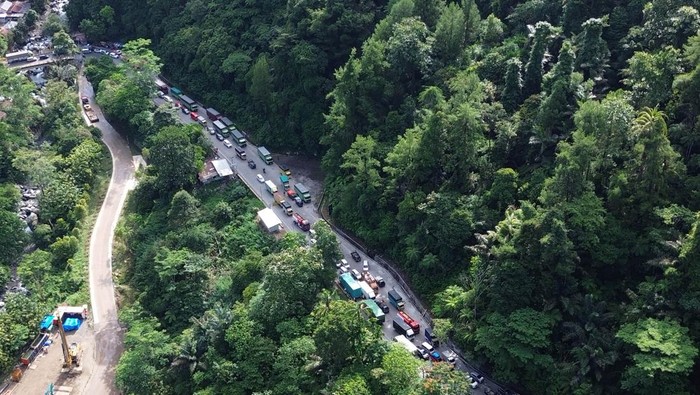 Foto udara antrean kendaraan saat bergantian melintasi tanjakan Sitinjau Lauik di Padang, Sumatera Barat, Senin (30/6/2025). Kemacetan panjang mencapai empat kilometer sejak Minggu (29/6) itu terjadi akibat sejumlah kendaraan besar seperti truk mengalami kerusakan saat melintasi tanjakan khususnya di kawasan Panorama Satu yang dikenal ekstrem dan berbahaya. ANTARA FOTO/Iggoy el Fitra