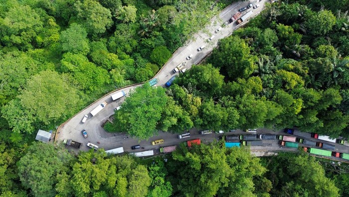 Macet 4 Kilometer di Sitinjau Lauik! Truk Mogok Bikin Jalur Padang Lumpuh Foto udara antrean kendaraan saat bergantian melintasi tanjakan Sitinjau Lauik di Padang, Sumatera Barat, Senin (30/6/2025). Kemacetan panjang mencapai empat kilometer sejak Minggu (29/6) itu terjadi akibat sejumlah kendaraan besar seperti truk mengalami kerusakan saat melintasi tanjakan khususnya di kawasan Panorama Satu yang dikenal ekstrem dan berbahaya. ANTARA FOTO/Iggoy el Fitra