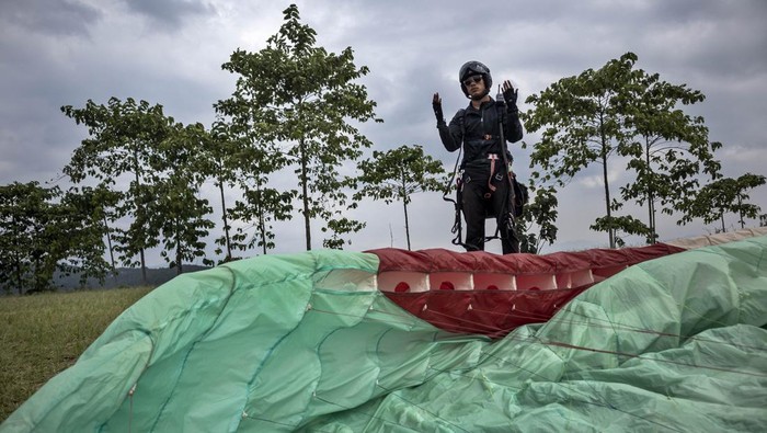 Wisatawan bersama pilot paralayang mengudara di atas kawasan Cihampelas, Kabupaten Bandung Barat, Jawa Barat, Senin (30/6/2025). Pariwisata olahraga (sport tourism) yang dikelola oleh Paralayang Bandung Raya tersebut menawarkan paket wisata paralayang dengan terbang dari ketinggian 1.080 meter di atas permukaan laut (mdpl) sekaligus mengenalkan potensi pariwisata di daerah itu. ANTARA FOTO/Abdan Syakura