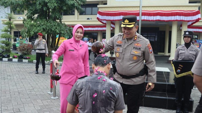 Kapolres Nganjuk AKBP Henri Noveri Santoso melakukan siraman kembang usai upacara kenaikan pangkat anggotanya