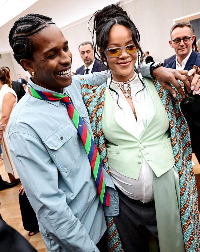 Pendiri Fenty Beauty itu menambahkan sentuhan akhir dengan sunnies berlensa kuning dan tatanan rambut sanggul kasual. Namun, aksesori paling mencolok adalah kalung choker Marlo Laz Artemis Cameo yang dikenakannya seharga US$ 70.000 atau sekitar Rp 1,1 miliar. Ia juga mengenakan anting-anting dari Briony Raymond, termasuk Sloan Ear Cuff bertatahkan berlian dan Sloan Stud Earrings. (Foto: Anthony Ghnassia/Getty Images for Dior Homme)