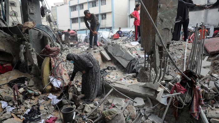 Palestinians inspect the damage at an UNRWA school sheltering displaced people that was hit in an Israeli air strike on Sunday, in Gaza City, June 30, 2025. REUTERS/Mahmoud Issa