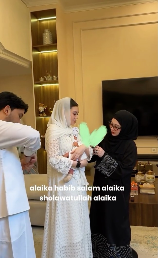 Satu per satu anggota keluarga tampak bergantian memotong rambut baby Arash. Mulai dari Thariq lalu dilanjutkan oleh ibunda Aaliyah, Reza Artamevia. Reza tampak hadir kenakan busana serba hitam. Foto: Instagram/@thariqhalilintar