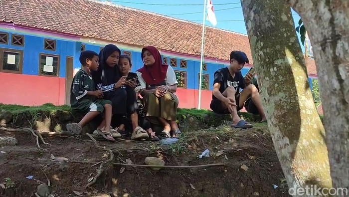 Anak anak di kampung susah sinyal berkumpul di lapangan untuk mencari jaringan Internet