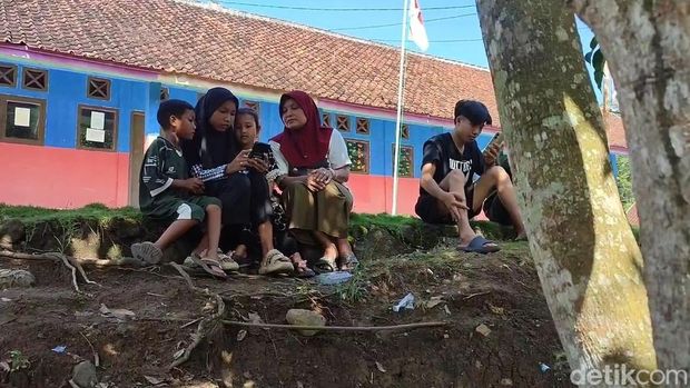 Anak anak di kampung susah sinyal berkumpul di lapangan untuk mencari jaringan Internet
