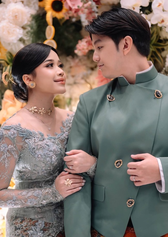 Brisia mengenakan kebaya panjang berwarna abu kehijauan dengan detail bordir dan payet yang elegan. Kebaya tersebut dipadukan dengan kain batik cokelat bernuansa klasik, menciptakan kesan anggun dan mewah. Foto: Instagram/@brisiajodie96