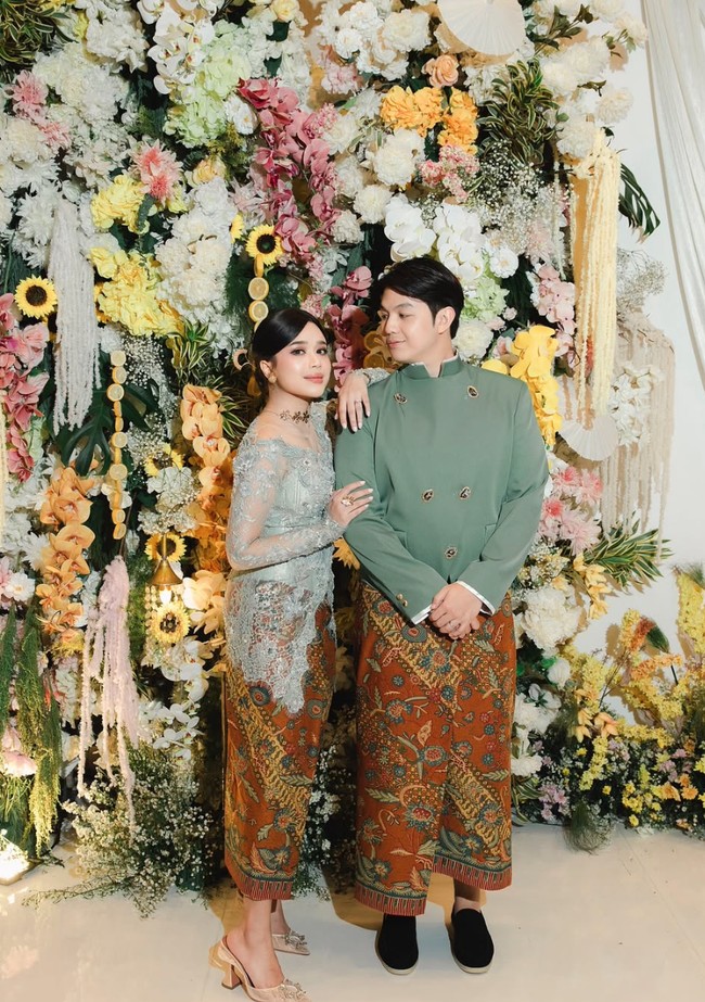 Lokasi lamaran didekorasi indah dengan kain putih dan bunga-bunga berwarna pastel yang cerah. Bunga warna-warni tersebut sekaligus menjadi background foto yang cantik dan sesuai dengan busana Brisia dan Alden. Foto: Instagram/@brisiajodie96
