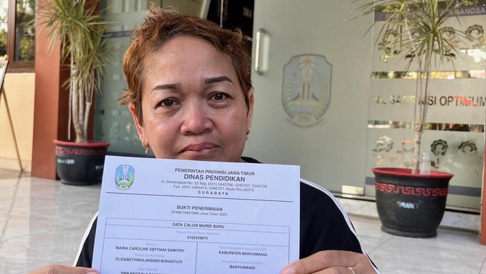 Elizabeth Wulandari Widiastuti menunjukkan bukti pemberitahuan anaknya diterima di SMAN 1 Giri Banyuwangi.