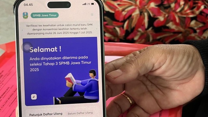 Elizabeth Wulandari Widiastuti menunjukkan bukti pemberitahuan anaknya diterima di SMAN 1 Giri Banyuwangi.