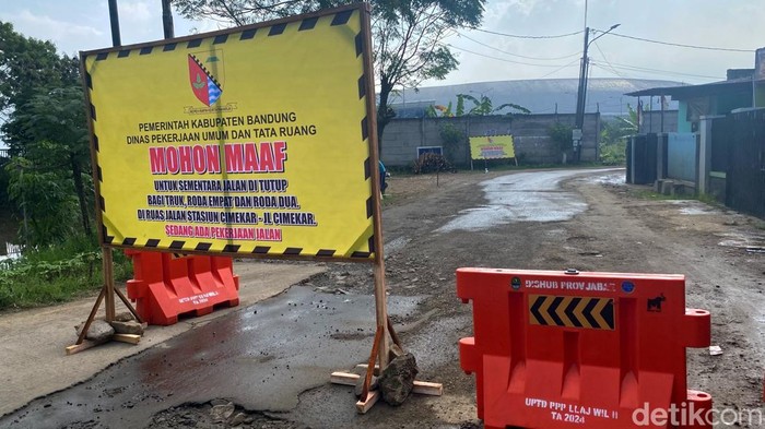 Penutupan sementara jalan menuju ke Stasiun Tegalluar akibat perbaikan jalan.