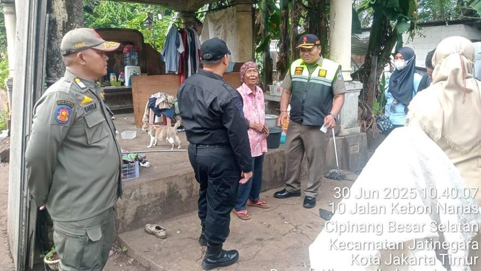 Kasatpol PP Kecamatan Jatinegara mengunjungi tempat tinggal Nenek Ira yang berada di atas makam etnis Cina, TPU Cipinang Besar, Jakarta Timur, Senin (30/6/2025).