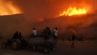 Rumah-rumah warga di sekitar hutan habis dilalap api. Setidaknya 20 rumah dilaporkan hancur total, hanya menyisakan dinding-dinding yang hangus terbakar. Mehmet Emin Menguarslan/Anadolu via Getty Images