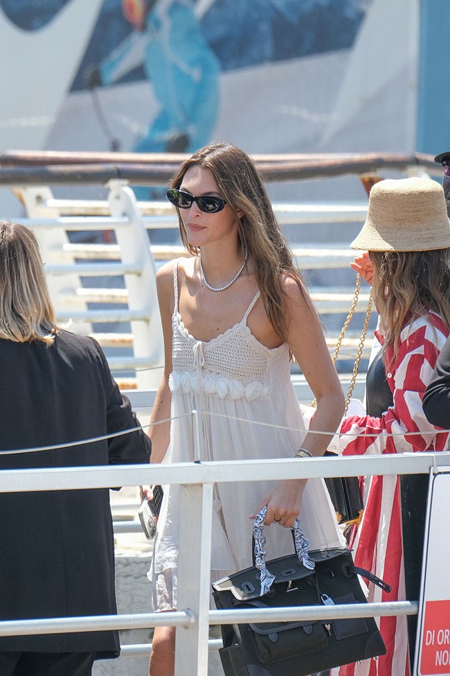 Aura modelnya terpancar berkat baby doll dress yang mengekspos kaki jenjangnya yang dibalut sepasang boots hitam. Tas Hermes yang ditentengnya menyumbangkan kesan mewah. (Foto: Stefano Mazzola/GC Images)