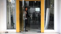 Petugas kepolisian berjaga di pintu masuk saat penyidik KPK melakukan penggeledahan kasus korupsi jalan di Kantor sementara Dinas PUPR Provinsi Sumatera Utara, Jalan Busi, Medan, Sumatera Utara, Selasa (1/7/2025). Foto: ANTARA FOTO/Yudi Manar