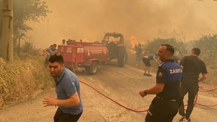 Firefighters and local residents respond to a wildfire in Menderes district of the Aegean city of Izmir, Turkey, June 29, 2025. (Reuters)