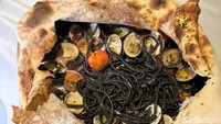 Di dalamnya ada pasta cartoccio yang berwarna hitam pekat. Toppingnya diisi dengan kerang, cumi, dan udang yang melimpah. Foto: Tim detikfood