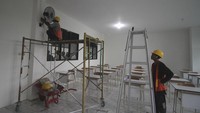Pekerja memasang kipas angin di ruang kelas Sekolah Rakyat di bangunan eks Kantor Bupati Pasuruan. Sekolah siap beroperasi pada tanggal 14 Juli mendatang dengan enam rombongan pelajar tingkat SMP dan SMA, dimana setiap kelasnya terdapat 25 siswa. Foto: ANTARA FOTO/Umarul Faruq