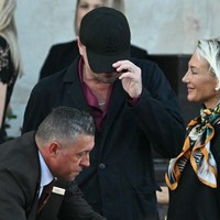 Keesokan harinya, Leonardo kembali muncul dengan topi yang sama. Kali ini, pria 50 tahun itu memakai satu set busana berwarna merah yang dengan blazer hitam sebagai luaran. (Foto: Stefano Rellandini/AFP)