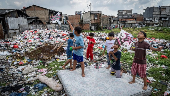 Warga berjalan di tumpukan sampah di Kampung Kiapang, Palmerah, Jakarta, Selasa (2/7/2025). Sampah yang didominasi limbah rumah tangga tersebut menumpuk diakibatkan minimnya kesadaran warga dalam menjaga kebersihan dan kelestarian lingkungan yang berpotensi menimbulkan dampak negatif terhadap kesehatan masyarakat setempat. ANTARA FOTO/Bayu Pratama S/bar