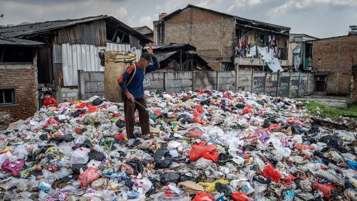 Warga berjalan di tumpukan sampah di Kampung Kiapang, Palmerah, Jakarta, Selasa (2/7/2025). Sampah yang didominasi limbah rumah tangga tersebut menumpuk diakibatkan minimnya kesadaran warga dalam menjaga kebersihan dan kelestarian lingkungan yang berpotensi menimbulkan dampak negatif terhadap kesehatan masyarakat setempat. ANTARA FOTO/Bayu Pratama S/bar