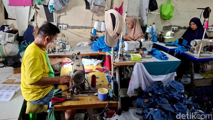 Perajin seragam sekolah di Sidoarjo Perajin seragam sekolah sedang menyelesaikan pesanan di Sidoarjo, Selasa (2/7/2025). Menjelng tahun ajaran baru pesanan seragam meningkat.