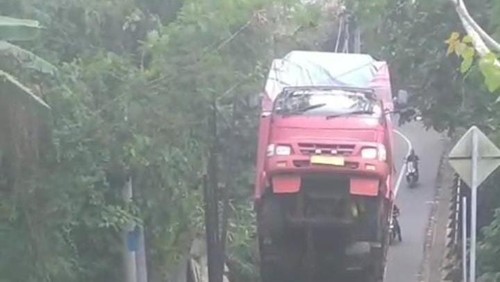 Truk pembawa triplek mogok dan bagian depan terangkat setelah gagal menanjak di jalur Desa Cepaka, Kecamatan Kediri, Tabanan.