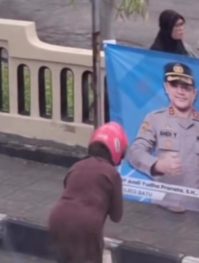 Bu Ira memberikan salam di hadapan spanduk bergambar Kapolres Batu AKBP Andi Yudha Pranata.