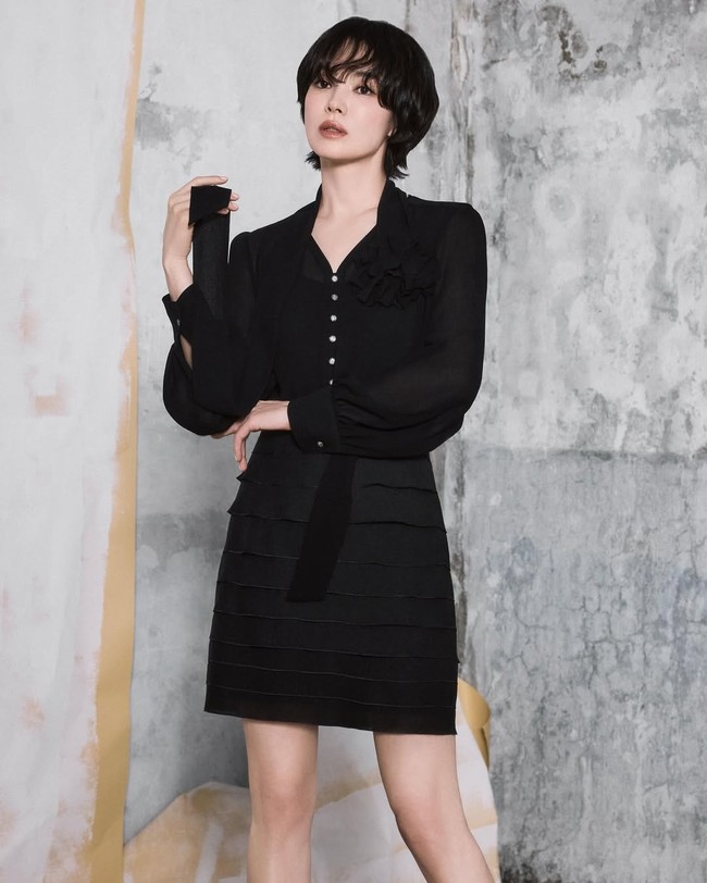 Tampil monokrom dengan busana serba hitam tak selalu membuat penampilan monoton. Song Hye Kyo sukses memadukan blouse dan rok mini hitam aksen layer untuk tampilan lebih formal tapi tetap stylish. Foto: Instagram/@kyo1122 @michaachannel