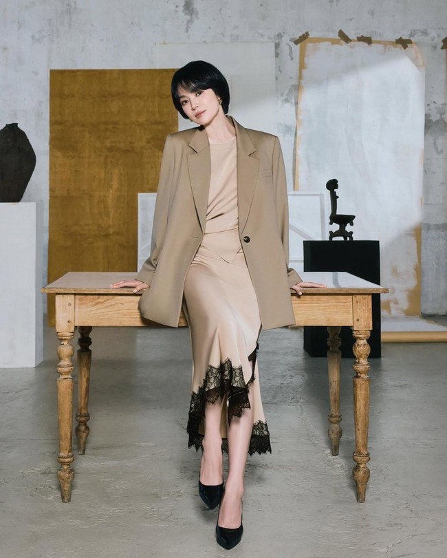 Song Hye Kyo memadukan dress satin nude aksen lace hitam di bagian hem, lalu melapisinya dengan oversized blazer beige. Look ini super stylish karena memadukan kesan feminin dan sedikit sensual, tapi tetap sopan dan wearable ke kantor. Foto: Instagram/@kyo1122 @michaachannel
