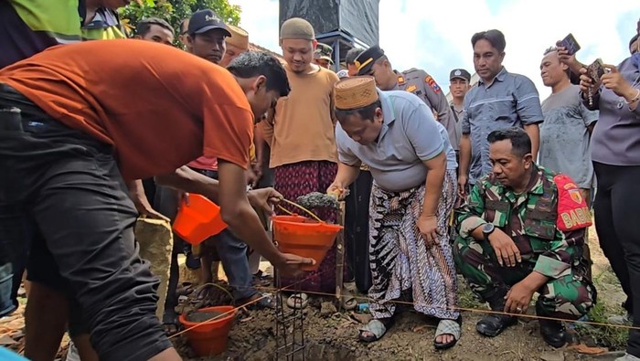 Haji Her saat melakukan peletakan batu pertama pembangunan rumah layak huni.