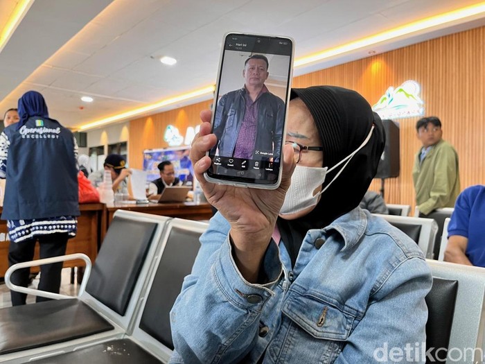 Istri Fauzi bin Awang menunjukkan foto suaminya WNA Malaysia diduga korban tenggelam KMP Tunu Pratama Jaya
