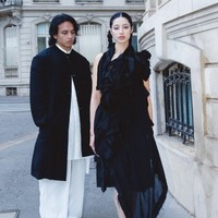 Saat menghadiri fashion show Yohji Yamamoto, pasangan ini tampil penuh karakter. Ameera, influencer asal Malaysia itu mencuri perhatian dengan dress hitam asimetris bergaya avant-garde dan rambut dikepang dua yang memberi kesan fierce. Foto: dok. Instagram @littlemisskhan