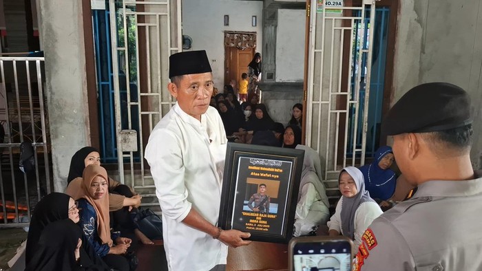 Keluarga korban menunjukkan foto Bripda Ghalidzan Raja Guna