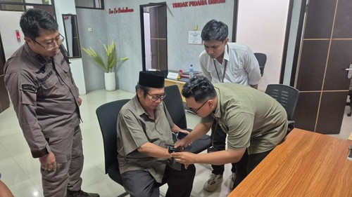 Mantan Bupati Lombok Tengah Suhaili Fadil Tohir saat dipasangkan gelang alat pengawas elektronik (APE) oleh jaksa penuntut, Kamis (3/7/2025).