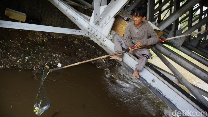 Wendi, memulung botol plastik bekas dari kolong jembatan Banjir Kanal Barat di seberang Pasar Rumput, Manggarai, Jakarta Selatan, Kamis (3/6/2025).