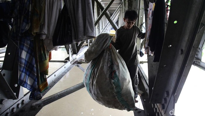 Wendi, memulung botol plastik bekas dari kolong jembatan Banjir Kanal Barat di seberang Pasar Rumput, Manggarai, Jakarta Selatan, Kamis (3/6/2025).