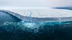Kalau ini potret gunung es dengan retakan di lautan air yang berwarna biru jernih. Pemandangan udara gletser Bråsvellbreen, bagian dari Austfonna Ice Cap di Svalbard, Norwegia dijepret oleh Thomas Vijayan. Foto: Thomas Vijayan/ The Inaugural International Aerial Photographer of the Year
