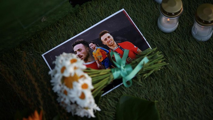 Flowers lie on photographs of Liverpools Portuguese soccer player Diogo Jota, who died in a car crash near Zamora, Spain, outside Gondomar stadium in Gondomar, Portugal, July 3, 2025. REUTERS/Pedro Nunes