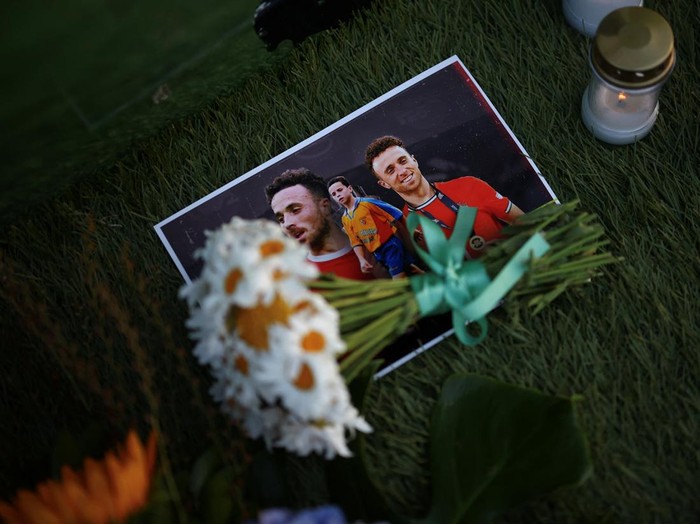Flowers lie on photographs of Liverpool's Portuguese soccer player Diogo Jota, who died in a car crash near Zamora, Spain, outside Gondomar stadium in Gondomar, Portugal, July 3, 2025. REUTERS/Pedro Nunes