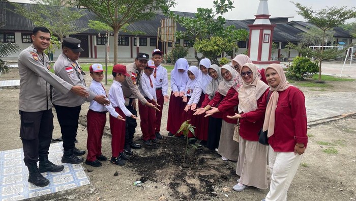 Polsek Tebing Tinggi melakukan penanaman pohon bersama siswa SDN 17 Alhair, pada Kamis (3/7/2025).
