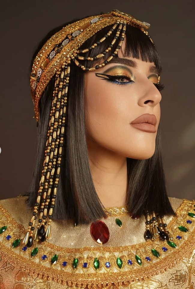 Eyeliner dramatis jadi kunci karakter Cleopatra versi Tasya. Garis hitam super tajam ditarik panjang membentuk double-wing ekstrem di atas dan bawah mata. Eyeliner bawah ditarik ke arah bawah dengan bentuk segitiga tajam, memberi kesan teatrikal. Foto: dok. Instagram @tasyafarasya @ttasyiiathasyia