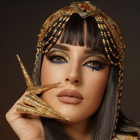 Tasya Farasya tampil dalam interpretasi Cleopatra yang glamor dan tajam. Makeup matanya didominasi warna emas metalik yang menyala, dipadu gradasi gelap di bagian crease dan aksen biru elektrik di bawah mata, menciptakan efek mata yang hidup dan berani. Foto: dok. Instagram @tasyafarasya @ttasyiiathasyia
