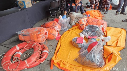 Petugas Inafis Polres Jembrana saat menyerahkan barang diduga milik penumpang dan inventaris dari kapal Tunu Pratama Jaya di Pelabuhan Gilimanuk, Bali, Sabtu (5/7/2025).