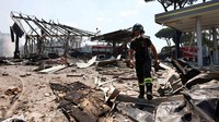 Petugas pemadam kebakaran dikerahkan ke lokasi untuk memadamkan kobaran api yang melalap area pompa bensin serta kendaraan di sekitarnya. Seorang petugas tampak berjibaku di tengah puing-puing bangunan yang porak-poranda akibat ledakan. REUTERS/Matteo Minnella