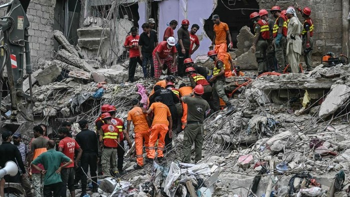 Rescue workers conduct a search operation amid the debris of a collapsed residential building in Karachi on July 5, 2025. Rescue teams pulled more bodies from the rubble of a five-storey building collapse in Pakistan overnight, taking the toll on July 5 to 14 as the recovery operation continued for a second day. (Photo by Rizwan TABASSUM / AFP)