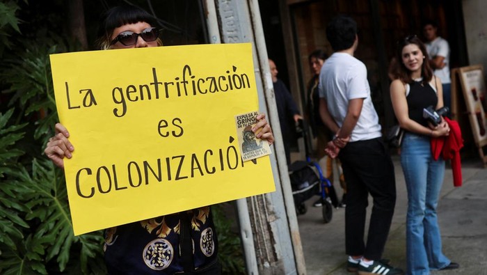 Protes Pecah di Condesa, Warga Meksiko Tolak Gentrifikasi Puluhan warga menggelar aksi protes di kawasan Condesa, Mexico City, Jumat (4/7/2025), menolak proses gentrifikasi yang mereka nilai telah mengusir penduduk lokal dan menaikkan harga sewa rumah secara drastis. REUTERS/Raquel Cunha