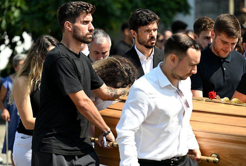 GONDOMAR, PORTUGAL - JULY 05: Rute Cardoso, Wife of Diogo Jota, leans on the arm of Ruben Neves, football player for Alhilal Saudi Club and the Portugal national team, as the coffin of Diogo Jota is carried out of the Church after a funeral held for Diogo Jota and his brother Andre Silva at Igreja Matriz de Gondomar on July 05, 2025 in Gondomar, Portugal. Diogo Jota was a professional football player for Liverpool FC and the Portuguese national team, while Andre Silva played for FC Penafiel in Portugal's second tier. The brothers died in a car accident in the province of Zamora, Spain, on July 3. (Photo by Octavio Passos/Getty Images)