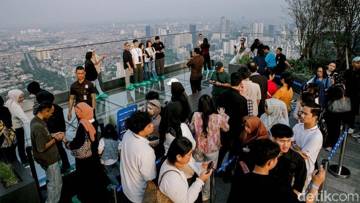 Sejumlah pengunjung tampak antusias menikmati panorama kota Jakarta dari ketinggian di “Up at Thamrin Nine”, Autograph Tower, Jakarta Pusat, Jumat (4/7/2024). Berada di ketinggian 385 meter, destinasi ini menawarkan pengalaman menakjubkan menikmati pemandangan 360 derajat Ibu Kota dari gedung pencakar langit tertinggi di Indonesia.