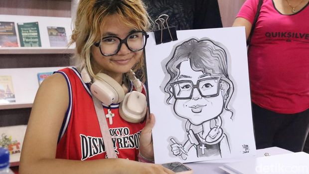 Suasana keramaian pengunjung di PKB 2025 yang menunggu giliran disketsa wajahnya oleh empat seniman karikatur di Art Center Denpasar, Sabtu (5/7/2025). (Aryo Mahendro/detikBali)